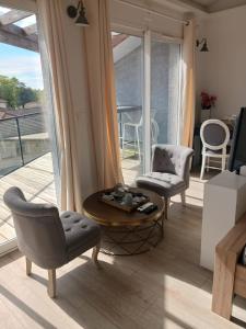 een woonkamer met 2 stoelen en een salontafel bij Calao in Villars-les-Dombes