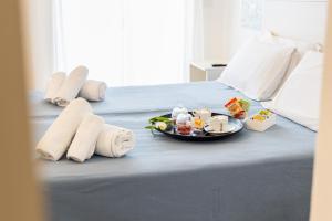 a bed with a tray of food and towels on it at Hotel Ristorante Montuori in Pimonte