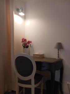 a desk with a chair and a lamp and flowers at Calao in Villars-les-Dombes