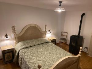 Casa Vacanze Sharazad في Bocchignano: غرفة نوم بسرير وطاولتين وكرسي