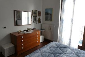 - une chambre avec un lit et une commode avec un miroir dans l'établissement Apartment il pescatore di sogni, à Pescara