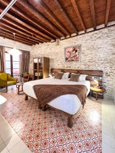 a bedroom with a large bed and a brick wall at Anahita Boutique Hotel in Málaga