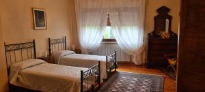 a bedroom with two beds and a window at Le Palme Apartment in Gargallo
