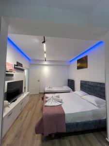 ein Schlafzimmer mit einem großen Bett mit einer Wand mit blauen Akzenten in der Unterkunft Lovely One-Bedroom Apartment with BBQ-grill! in Sarandë