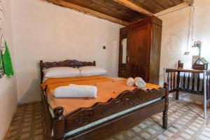1 dormitorio con cama de madera y toallas en Book Hotel, en Kutaisi