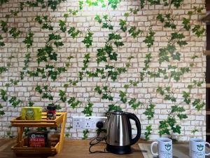 Una pared de ladrillo con hiedra verde. en Twilight Villas, en Rattota