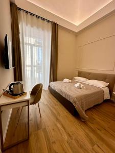 ナポリにあるMonaciello All'Albaのベッドルーム1室(ベッド1台、デスク、窓付)