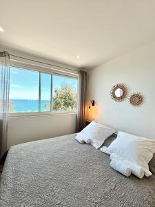 - une chambre avec un lit et une grande fenêtre dans l'établissement Residence Canella, à Sari-Solenzara