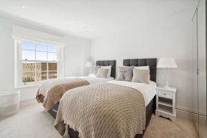 1 dormitorio blanco con 2 camas y ventana en Oakdale & The Regal at Latchmere Hse en Richmond