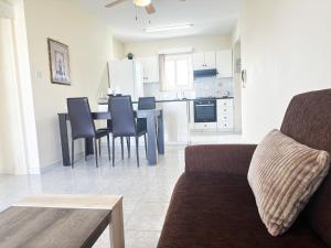 a living room and kitchen with a couch and a table at Serenity Sunrise Holiday Apt - Larnaca in Larnaka +18 photos