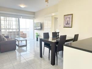 a dining room and living room with a table and chairs at Serenity Sunrise Holiday Apt - Larnaca in Larnaka