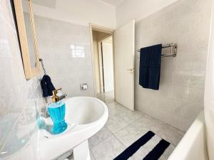 a bathroom with a blue vase on a sink at Serenity Sunrise Holiday Apt - Larnaca in Larnaka