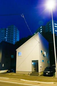 a white building with a street light next to it at TEINE WHITE HOUSE in Sapporo +49 photos