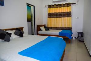 a room with two beds and a chair in it at Orr's Hill Sea Side in Trincomalee