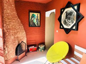 a room with a yellow chair and a fireplace at AL MAQAM ATAQAFI in Tahannout