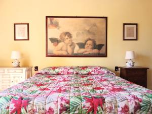 a bedroom with a bed and a painting on the wall at Podere Casato in Montespertoli