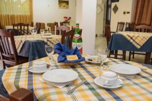 una mesa con platos y copas y una botella de vino en B&B Giardini di Iside e Osiride, en Isquia