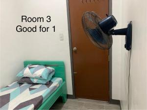een kamer met een bed en een ventilator naast een deur bij Romblon Transient House 2nd Floor in Romblon