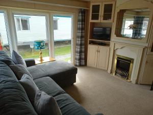 a living room with a couch and a fireplace at Mablethorpe L17 Caravan in Mablethorpe