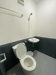 een badkamer met een toilet en een wastafel bij MV Tourist Inn in Puerto Princesa City
