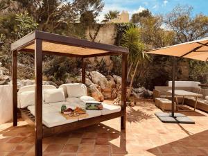 a patio with a bed and an umbrella at Ibiza Dream Villa Denia, Seaview, Pool, BBQ, Airco, Wifi in Denia