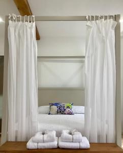 a bed with white curtains in a room at Pied à Terre Saulieu in Saulieu