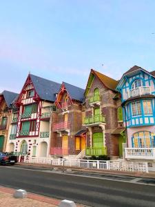 um grande edifício com casas coloridas no lado da rua em La Favorite - app plage à Mers em Mers-les-Bains