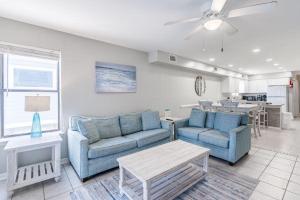 uma sala de estar com dois sofás azuis e uma mesa em Bonhomme Richard West em Gulf Shores