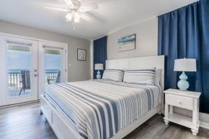 um quarto com uma cama com paredes azuis e uma janela em Bonhomme Richard West em Gulf Shores