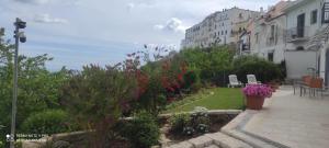 a garden with flowers and plants and buildings at VerdeMare in Rodi Garganico
