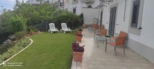 a patio with chairs and tables and a lawn at VerdeMare in Rodi Garganico