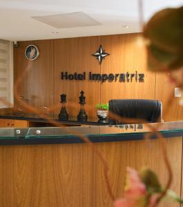 a hotel margaritaville sign on a reception desk at Hotel Imperatriz in Telêmaco Borba