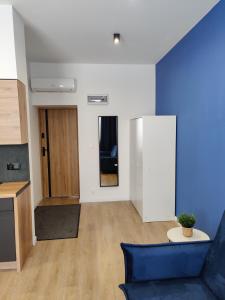 ein Wohnzimmer mit einem blauen Sofa und einem Tisch in der Unterkunft STUDIO BLUE BIRD PIĘKNA 2 wejście na kod CENTRUM in Pabianice