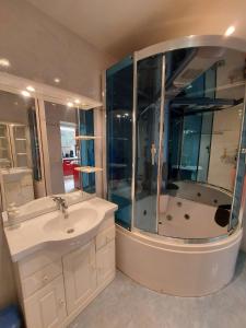 a bathroom with a shower and a sink and a tub at Granville : appart. vue mer proche centre ville in Granville