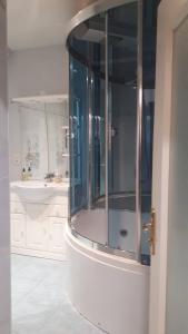 a bathroom with a shower with a glass door at Granville : appart. vue mer proche centre ville in Granville