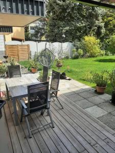 a patio with a table and chairs on a deck at Garten Apartement Strebersdorf in Vienna