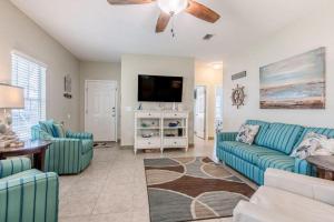 a living room with blue couches and a flat screen tv at Orange Beach Villas - Casa Bella in Orange Beach