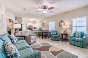 a living room with blue couches and a kitchen at Orange Beach Villas - Casa Bella in Orange Beach