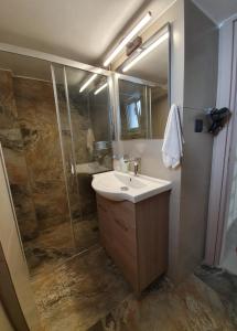 een badkamer met een wastafel en een douche bij Stephie's apartment by the sea in Rafina