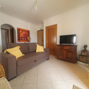 a living room with a couch and a flat screen tv at Pérola do Sol in Vila Real de Santo António