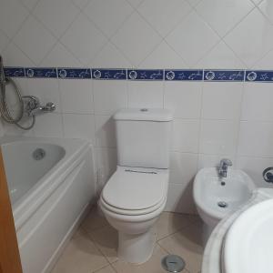 a bathroom with a toilet and a tub and a sink at Pérola do Sol in Vila Real de Santo António