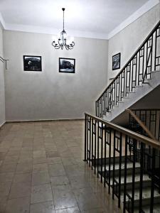 an empty room with stairs and pictures on the wall at Cozy apartment in the city center Mtatsminda in Tbilisi City