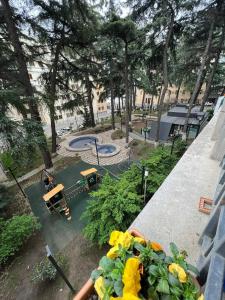 a view of a park with a playground with yellow flowers at Cozy apartment in the city center Mtatsminda in Tbilisi City