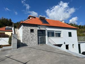 a white house with an orange roof at Success House in Calheta