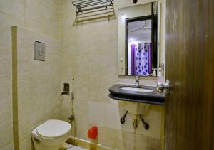 a bathroom with a toilet and a sink and a mirror at Hotel University Stay @ A1Rooms in New Delhi