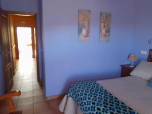 a blue bedroom with a bed and a hallway at Hotel Apartamento Rural Finca La Media Legua in Aracena