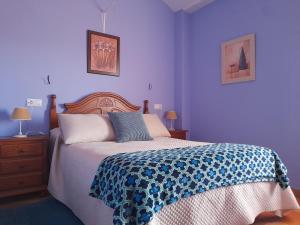 1 dormitorio con 1 cama con pared azul en Hotel Apartamento Rural Finca La Media Legua, en Aracena