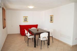 comedor con mesa negra y sillas blancas en Nuovissimo appartamento a due passi dalla spiaggia di Maladroxia C61 en Maladroscia