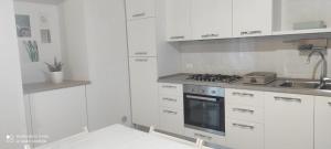 a white kitchen with a stove and a sink at VerdeMare in Rodi Garganico
