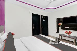 Cette chambre comprend un lit et une télévision. dans l'établissement OYO Hotel Lotus, à New Delhi